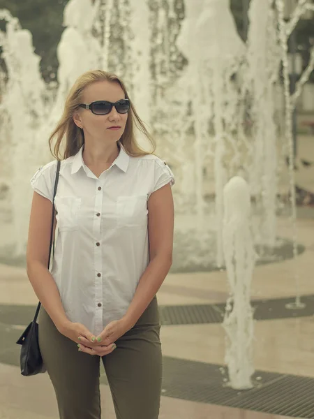 Mujer en gafas de sol en el fondo de la fuente . — Foto de Stock