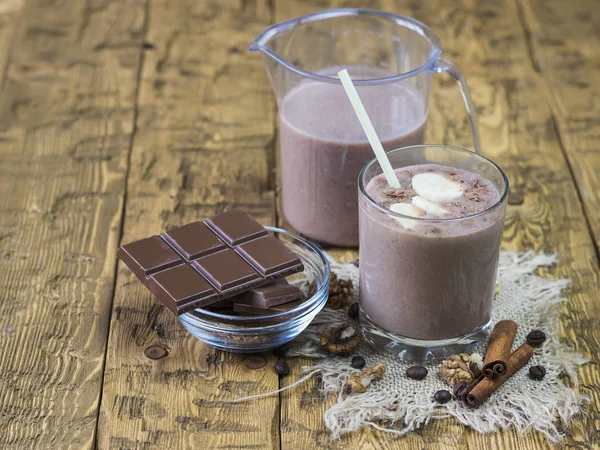 Coklat dan coklat-pisang smoothie dengan kayu manis di atas meja pedesaan . — Stok Foto