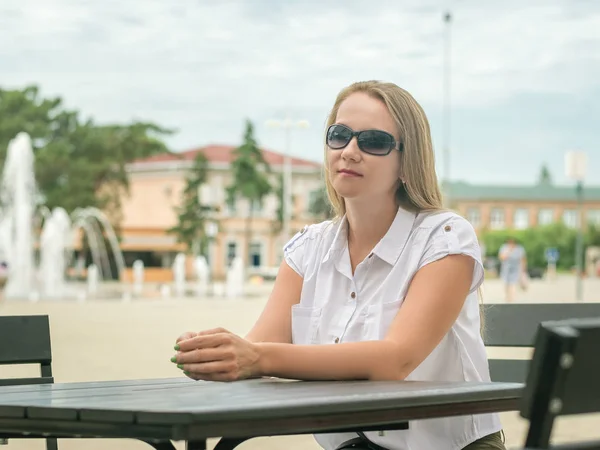 Hermosa mujer en el café urbano en el fondo de la ciudad vieja . — Foto de Stock