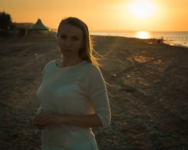 Retrato de silueta de una mujer vestida de blanco en la playa de la tarde . — Foto de Stock