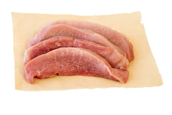 Τεμάχια του νωπού χοιρινού κρέατος σε χαρτί που απομονώνονται σε λευκό φόντο. — Φωτογραφία Αρχείου