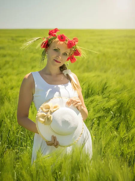 Bir alanda yeşil Rye elinde şapka ile güzel kadın.