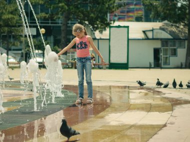 Bir sürü şehir çeşme kızların yanında asılı güvercin.