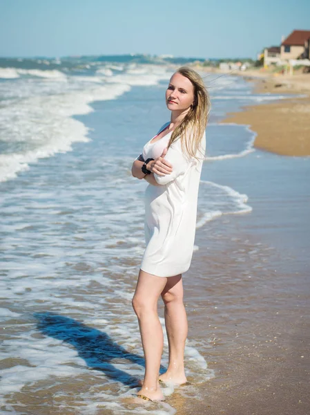 İle beyaz elbiseli bir kadın portresi güneş yüzü tarafından deniz kör..