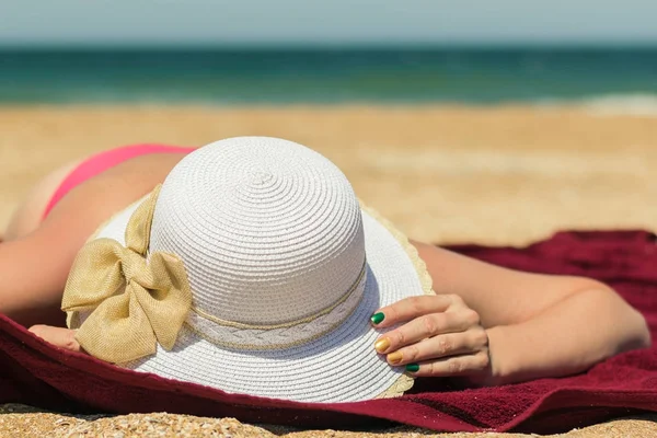 Bir kadının şapkasını karşı deniz tutar..