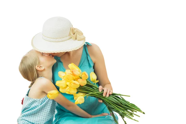 Mère avec sa fille en robes bleues avec un bouquet de tulipes isolées sur fond blanc . — Photo