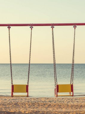 İki gün batımı deniz akşam arka plan ile zincir sallanır.