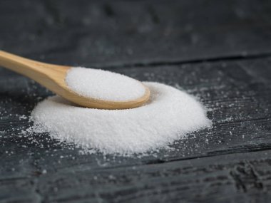 Tahta kaşık hafif ahşap üzerine tuz ince ahşap bir masa üzerinde bir yığın.
