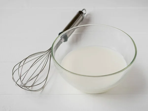 Batido y tazón de cristal con leche sobre mesa de madera blanca . — Foto de Stock