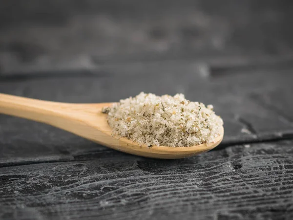 Herbal dengan garam laut besar dalam sendok di atas meja kayu gelap . — Stok Foto