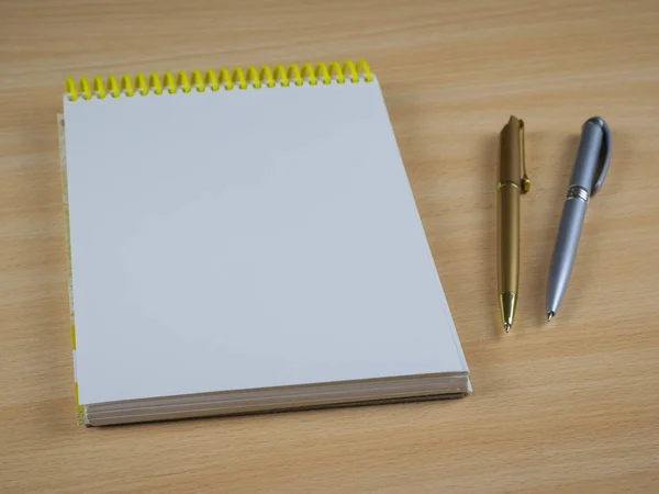 Duas canetas esferográficas com caderno numa mesa de madeira. Lugar para o seu texto . — Fotografia de Stock