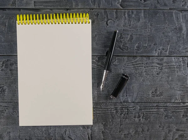 Notebook en vulpen boven op een donkere tafel bekijken. Plaats voor uw tekst. — Stockfoto