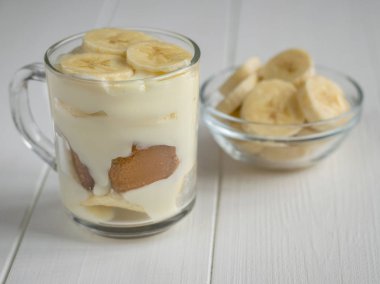 Cam kase adet muz ve muz puding bir fincan beyaz bir tablo ile.