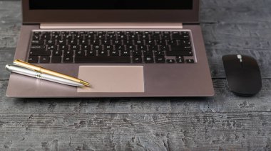Gri defter ve vintage ahşap masa üzerinde iki tükenmez kalem. İşyeri Tasarımcısı.