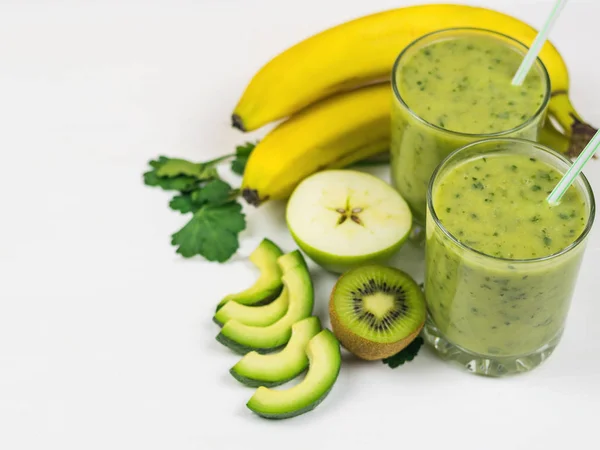 Frullato di avocado, banana, arancia, limone e kiwi preparato al momento su un tavolo di legno bianco. Cibo vegetariano a dieta. Alimenti crudi . — Foto Stock