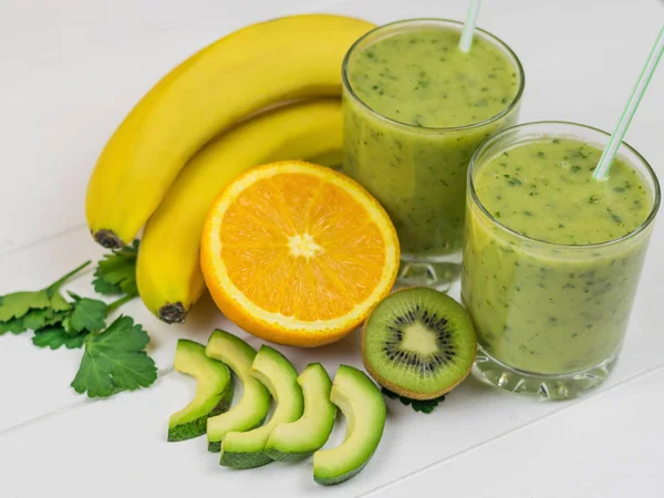 Taze hazırlanmış bir yüzlü, avokado, muz, maydanoz, limon, portakal ve kivi ahşap rustik masa üzerinde. Diyet vejetaryen yemekleri. Çiğ gıdalar.