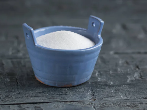 Jemně modrá Solnička ve tvaru kbelíku na černé rustikální kuchyňská sůl. — Stock fotografie