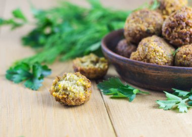 Ahşap bir masa Tahin soslu marul üzerinde taze pişmiş falafel yaprak.