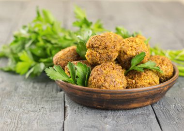 Taze Tahin soslu koyu ahşap bir masa üzerinde bir kil tabakta falafel yaptı.