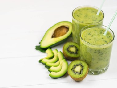 Taze hazırlanmış bir yüzlü avokado, maydanoz, limon ve kivi beyaz bir tablo. Diyet vejetaryen yemekleri. Çiğ gıdalar. Detoks.