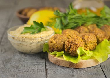 Taze sos Tahin ve otlar ve limon ile bir kesme tahtası üzerinde falafel yaptı.