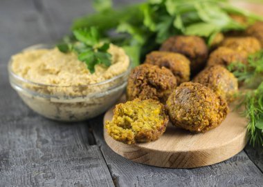 Taze sos Tahin ve otlar ile bir kesme tahtası üzerinde falafel yaptı.