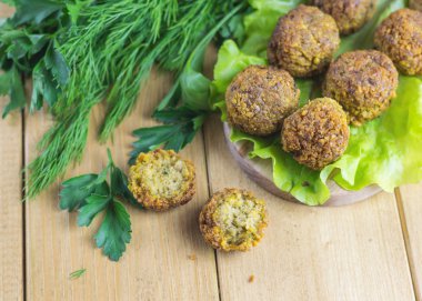 Maydanoz ve dereotu ahşap bir masa marul yaprağı üzerinde ile taze hazırlanmış falafel.
