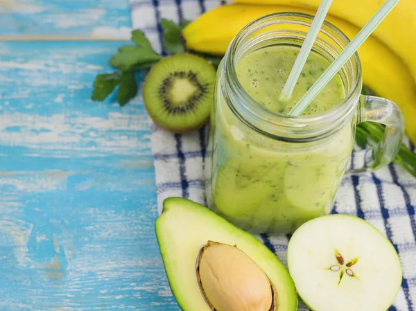 Dvě modré koktejlové brčka v poháru smoothie, avokádo, kiwi a banán. Pohled shora. Strava vegetariánská strava. Syrové potraviny. — Stock fotografie