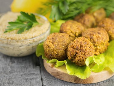 Taze sos Tahin ve maydanoz ve limon ile bir kesme tahtası üzerinde falafel yaptı.
