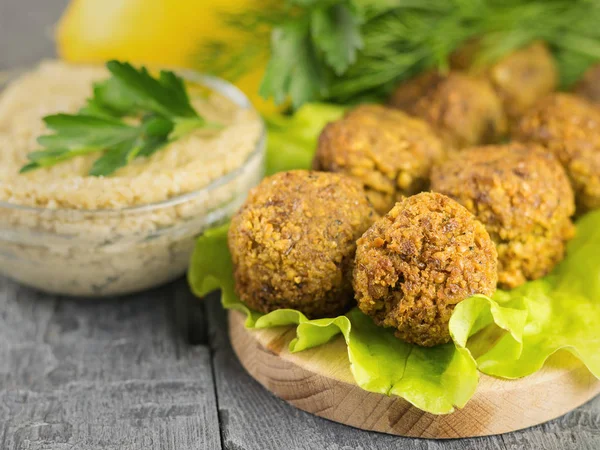 Freshly made falafel on a cutting Board with sauce tahina and parsley and lemon. — Stock Photo, Image