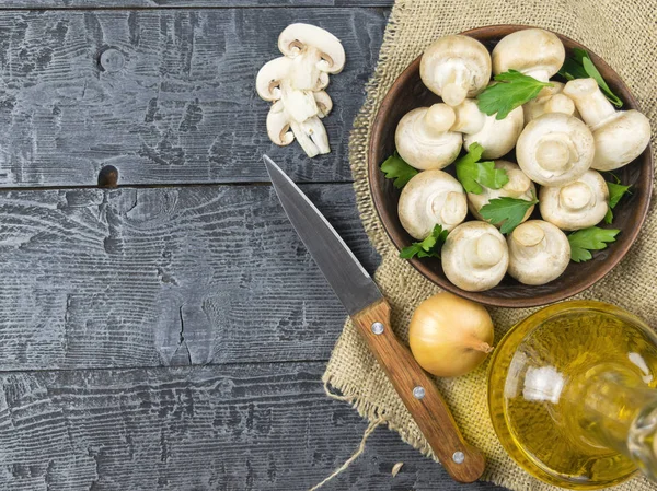 Свежие грибы с листьями петрушки и луком и маслом на деревенском деревянном столе. Вегетарианская еда на столе. Вид сверху . — стоковое фото
