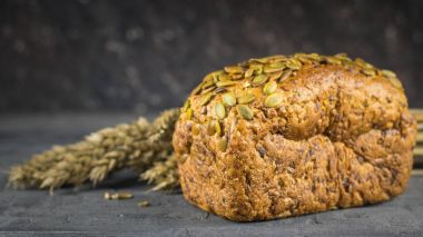 Kulakları buğday ekmek un karanlık bir tablo yanında.