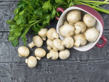 Taze mantar mor bir bardaktan rustik bir masanın üzerine dökülür. Vejetaryen yiyecekler tablodur.