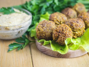 Taze sos Tahin ve maydanoz ve dereotu ile bir kesme tahtası üzerinde falafel yaptı.