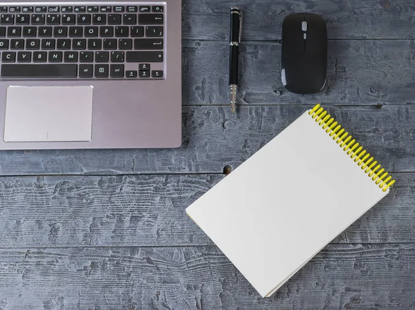 Opened the notebook, notebook, fountain pen and mouse on a wooden table. Workplace designer.