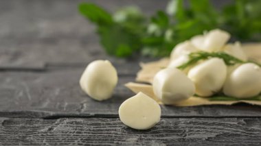 Taze mozzarella peynir maydanoz ile ahşap bir masa üzerinde yapılmış. Seçici odak.