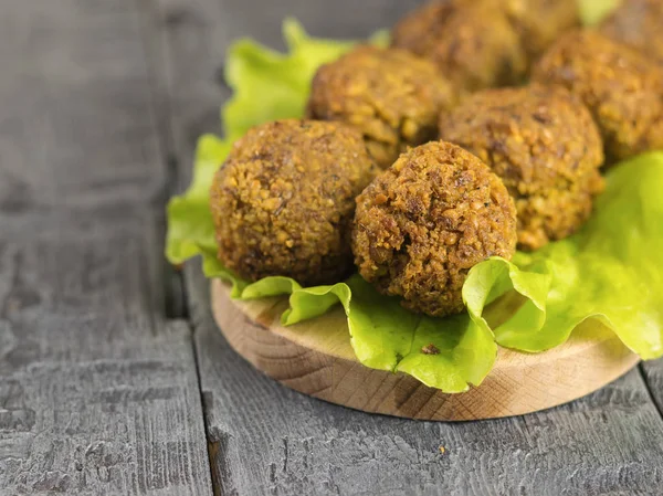 Freshly made falafel on a salad leaf on a cutting Board on a dark wooden table. — Stock Photo, Image