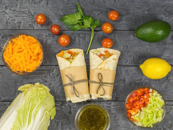 The cherry tomatoes out of the two vegetable rolls on a wooden table. Vegetarian food. — Stock Photo, Image