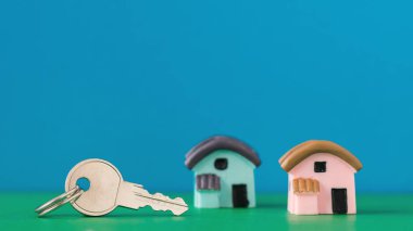 İki minyatür ev ve anahtar üstünde bir renk tablosu.