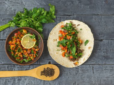 Tortilla Meksika Taco, vejetaryen salata ve koyu ahşap bir masa üzerinde baharat pişirme.