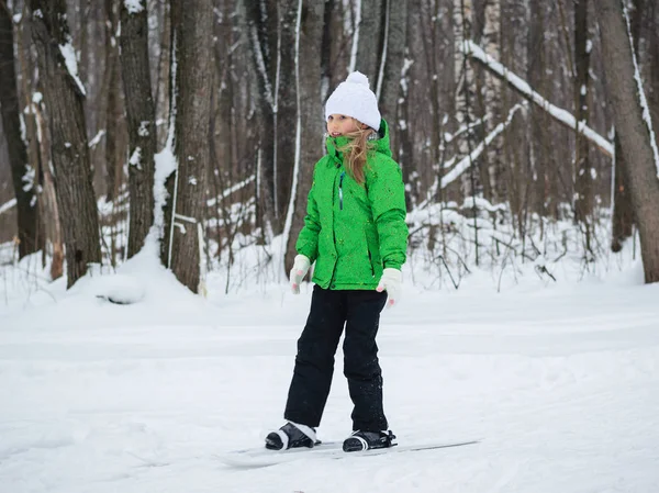 Flicka kul skidåkning genom vintern skogen. — Stockfoto