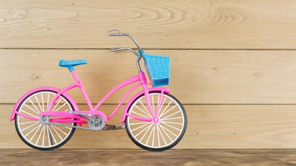 Modèle rose de vélo pour enfants sur le plancher brun en bois . — Photo