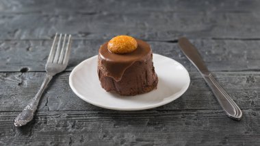 Pasta çatal ve kaşık koyu ahşap bir masa üzerinde beyaz bir plaka üzerinde.