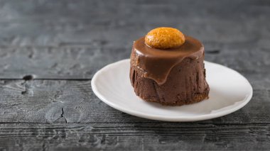 Koyu ahşap bir masa üzerinde beyaz bir tepside kek.