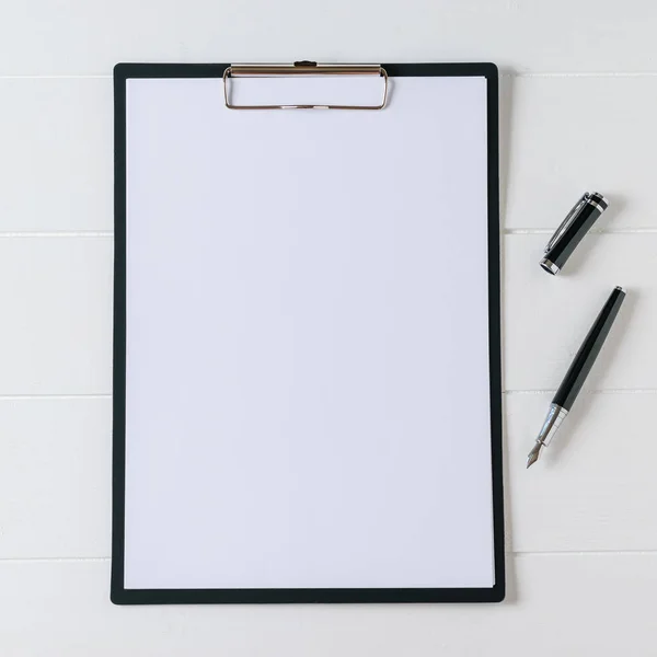 Notebook met pen op een witte houten tafel. Het uitzicht vanaf de top. — Stockfoto