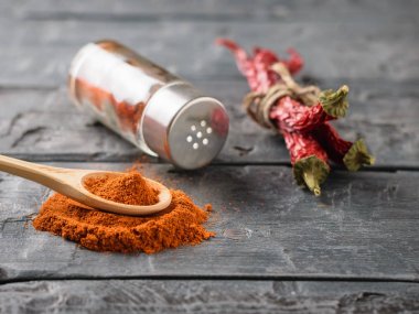 Bir tahta kaşık biber biber, bir kavanoz ve bakla koyu ahşap bir masa üzerinde bir grup ile.