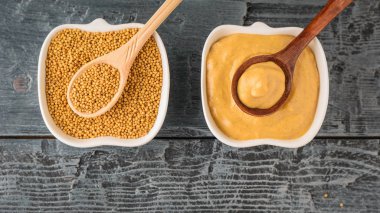 Kupa Kupası kaşık ve rustik masada hardal sosu ile kaşık ve hardal tohumları ile. Üstten Görünüm.