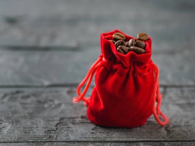 Karanlık bir rustik tabloda kavrulmuş kahve ile kırmızı çanta.