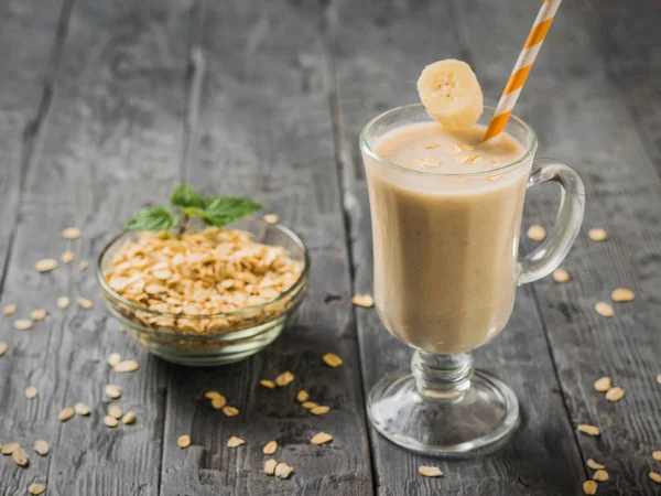 Pisang smoothie dengan oatmeal di atas meja kayu. Vegetarian smoothie . — Stok Foto