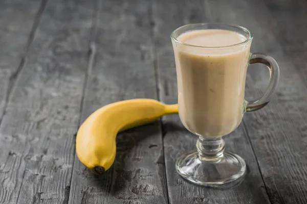 Bananen-Smoothie mit Haferflocken und Banane auf einem Holztisch. vegetarischer Smoothie. — Stockfoto